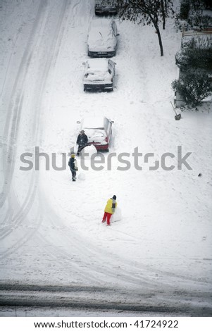 snow covered cars and children in fun