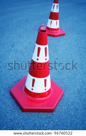An image of caution cone sign on asphalt road.