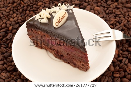 Dark chocolate cake with cherries on the background of coffee beans