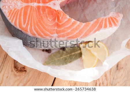 Raw salmon steak red fish and spices on wooden board. Top view