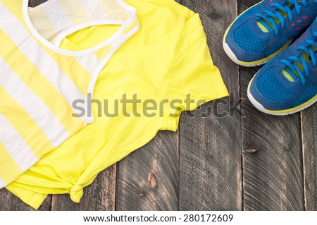 Old sport shoes and sportswear on a dark wooden background. Sport equipment
