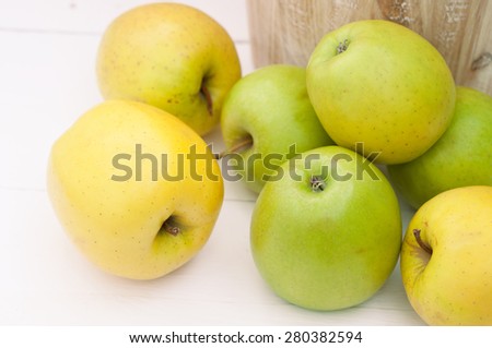 Green and yellow apples in an old wooden bucket