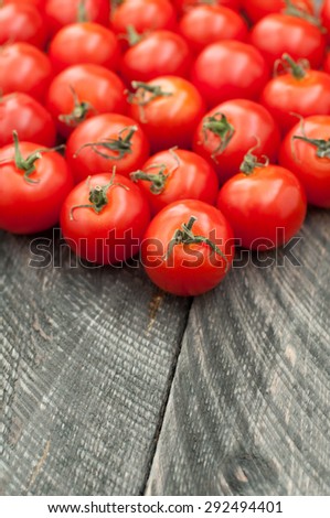 Cherry tomatoes on old wooden table. Vegetables background. Rustic style.