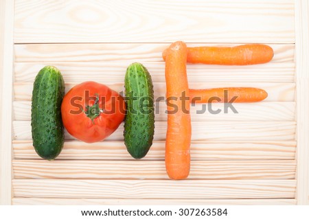 Healthy food concept. The letters H and F made of cucumbers, tomato and carrots. Vegetables background. Top view