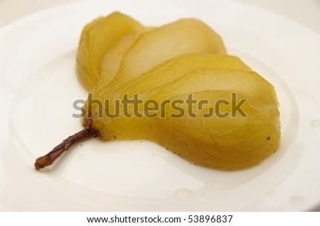 A delicious vanilla bean poached pear. On a plate and ready to eat.