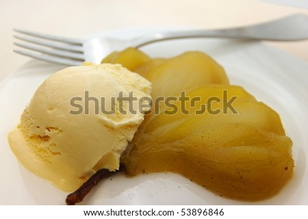 A delicious vanilla bean poached pear and ice-cream dessert. On a plate and ready to eat.