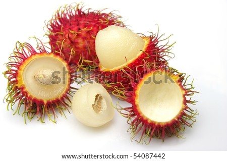 Hairy, red Rambutan fruit (Nephelium lappaceum). Whole fruits, some peeled, showing white edible flesh and seed. Shot on white.