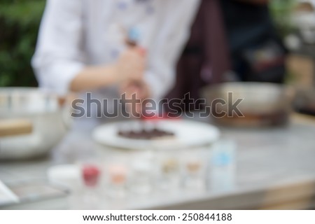Defocused and blurred image for background of pastry chef\'s chocolates demonstration