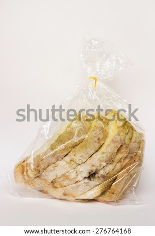 Mold on bread in plastic bag , portion of bad food with toxic mold, spoilage colored spores.