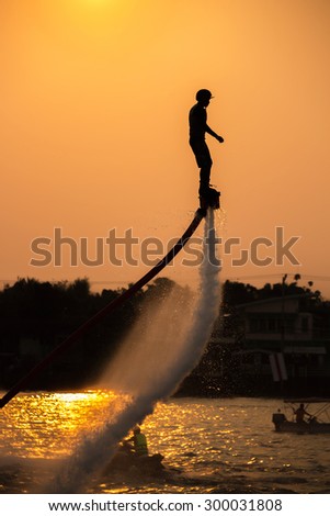 The new spectacular sport,Silhouette of a man showing the fly board in the river of Thailand