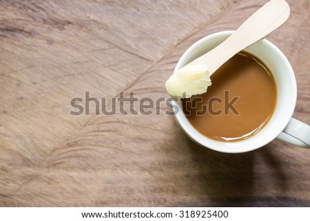 Coffee blended with butter tester good. New trend may forever change the way you drink coffee. Instead of the usual cream and sugar, on wooden background  with copy space