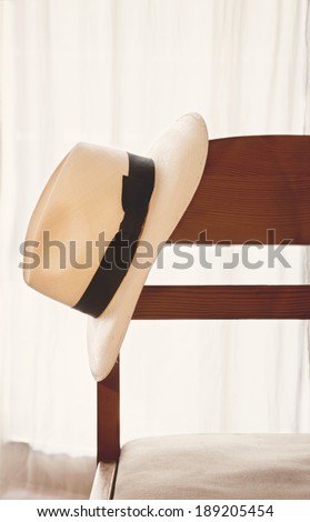Elegant hat hanging on the chair