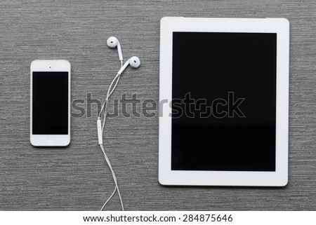 Digital tablet, mobile phone and earphones.