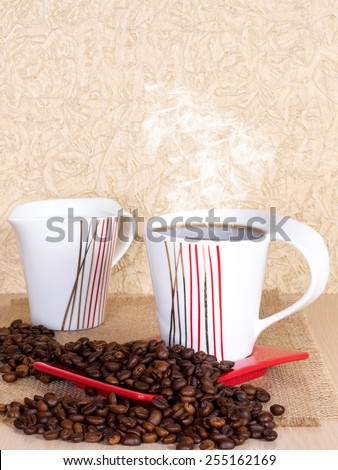 Cup of coffee with saucer, milk jug and coffee beans on the table