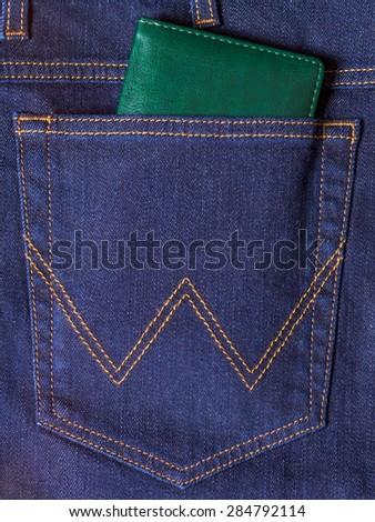 Green notebook in the back pocket of jeans
