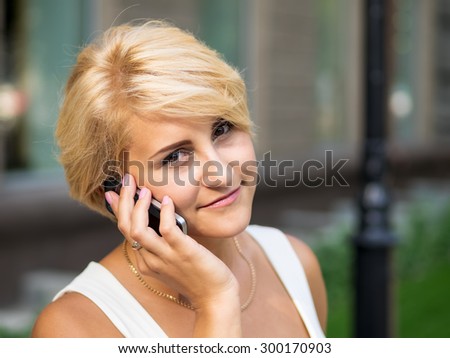 Young girl with the cellular phone in the hands
