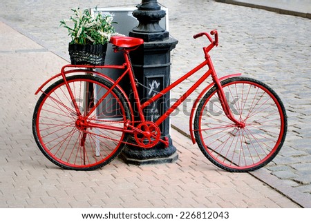 a bicycle is red with the small basket of colors