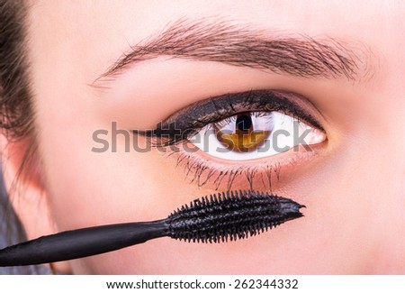 Girl makes eye makeup mascara
