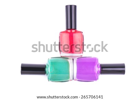 Three multi-colored nail polish, red, turquoise and purple lie on a white background
