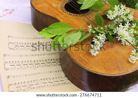 Vintage guitar with music notes and blossom branch
