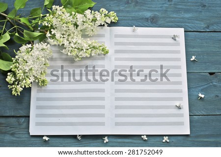 Blossom white lilac with music notebook