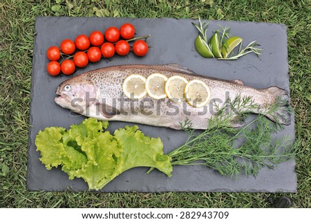 Fresh rainbow trout with tomatoes and salad leaves
