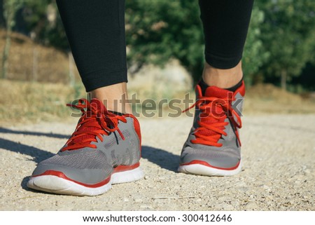 Feet of a woman runner in a sand track