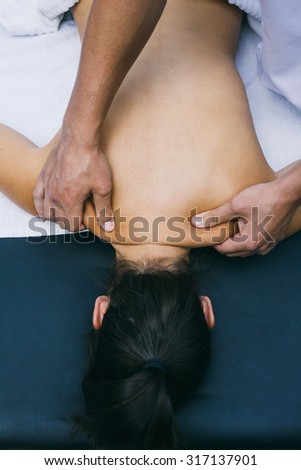 Physiotherapist massaging the shoulders of a patient