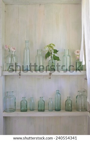 Flowers in vintage vases on a white shelf