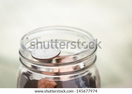 Jar of change with quarter on lip - room for text