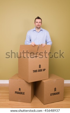 Man packing boxes smiling, getting ready to move homes