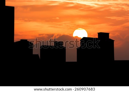 silhouette of Sunset over some of high old building