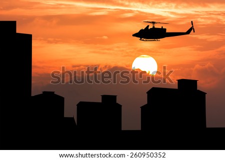 silhouette of high old building and  helicopter fly on sky sunset  background