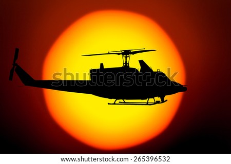 Silhouette of helicopter on big sunset