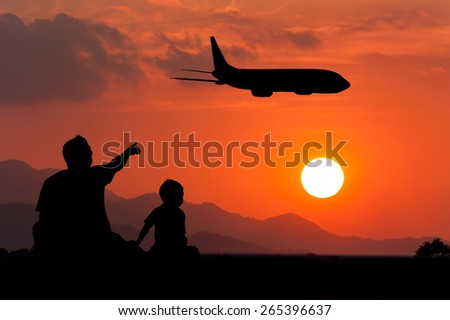 father use hand point Airplane on the sky at sunset  his son see