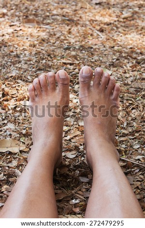 women feet on the background of soil and dry leaves