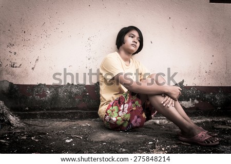 asian girl sad alone sitting with white bear near old wall cement,vintage tone