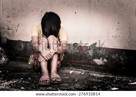 asian girl sad alone sitting near old wall cement,vintage tone