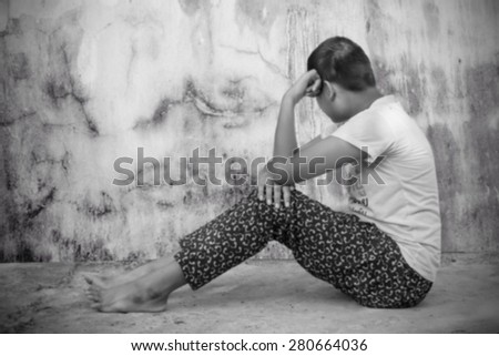 blurry asian girl sad alone sitting near old wall cement,black and white tone