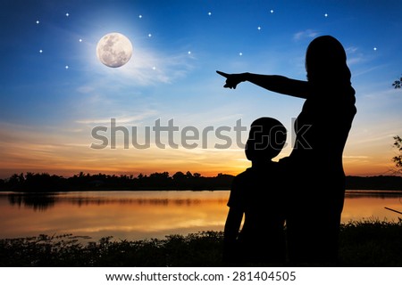 Mother embraces son And hand pointing to her son see the full moon.