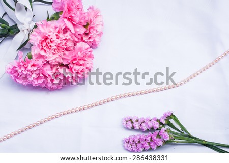 pink carnation floral and pearl on  white cloth background