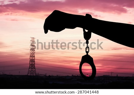 silhouette of hand women in shackle on city sunset background