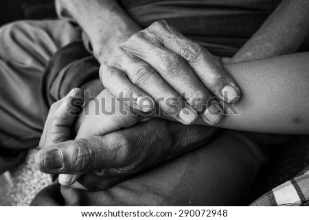 asian kids little boy hand touches and holds an old man wrinkled hands,black and white tone