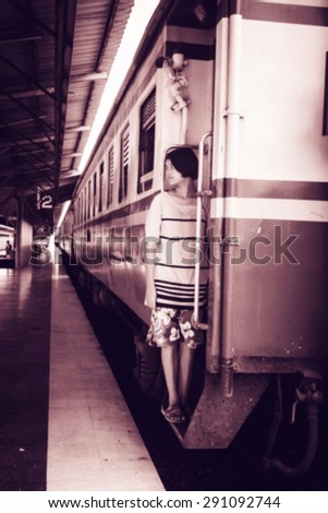 blurry abstract of the asian girl standing alone and hand hold white bear at inner train ,vintage tone