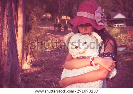 asian cute girl standing alone at the park and hand bear hug,vintage tone