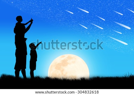 Silhouette of father and son see star on the sky