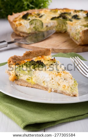 Quiche with broccoli and cheese on a white plate. Piece of homemade vegetable pie.