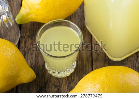 Lemon liquor Limoncello on wooden table. Italian alcoholic beverage. Small shot.