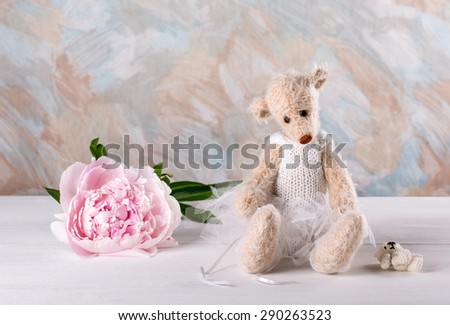 Sad teddy bear and  pink peony flower