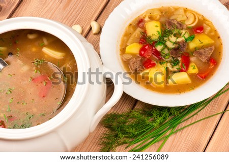Hungarian hot soup on the wooden background.